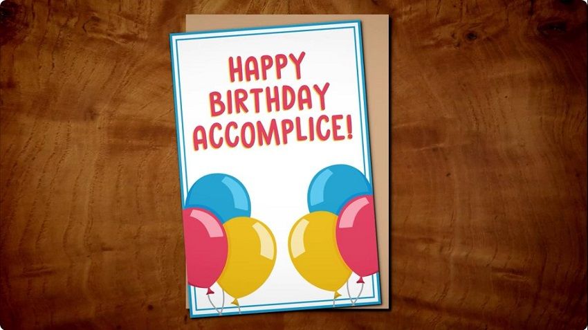 A card with "Happy Birthday Accomplice!" written across the top & colourful birthday balloons drawn below.