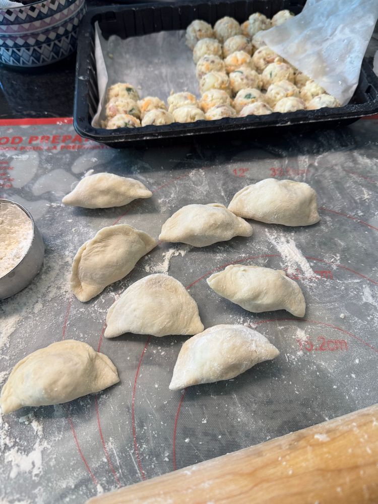 pre portioned filling & roughly-closed perogies on white mat