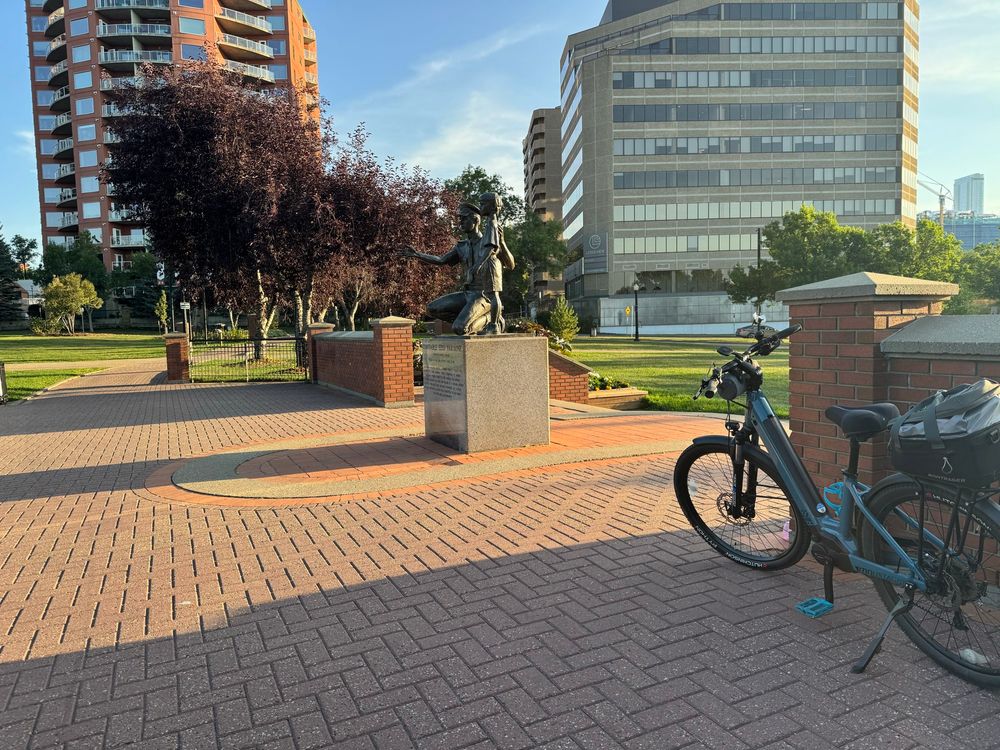 Lone bike parked near a statue at a park 