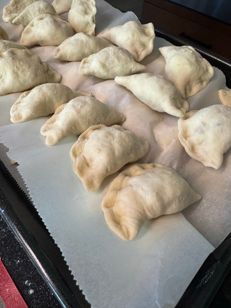 Pinched perogies double layered on black pan 