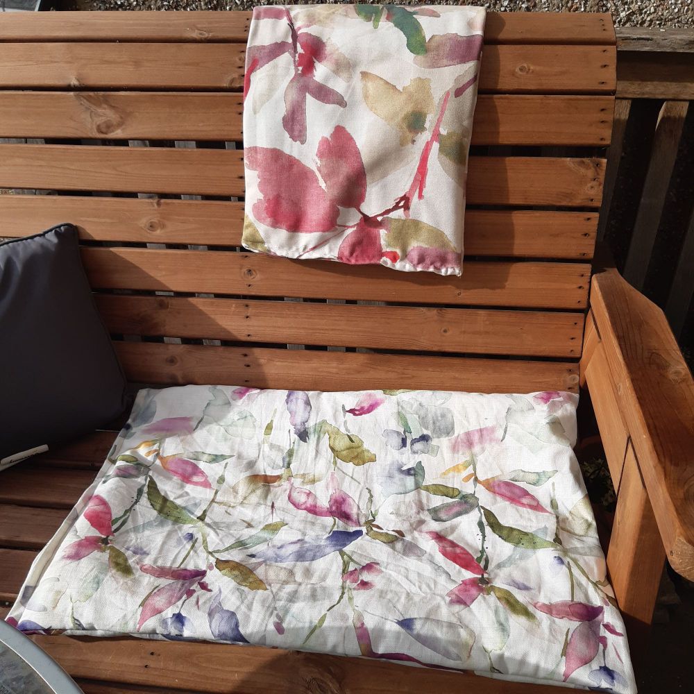 Handmade floral cushions on a wooden bench