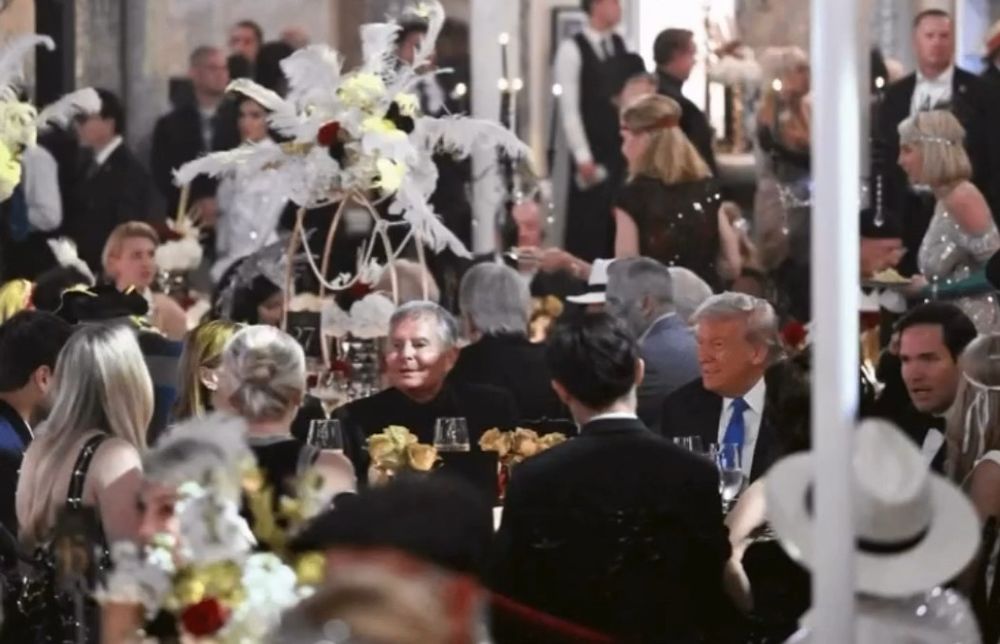 Another shot of Trump seated at the table. Picture mostly to show him at this opulent event in Mar a Lago. Lots of people in the background and foreground, mostly white and Hispanic (ie Rubio) 