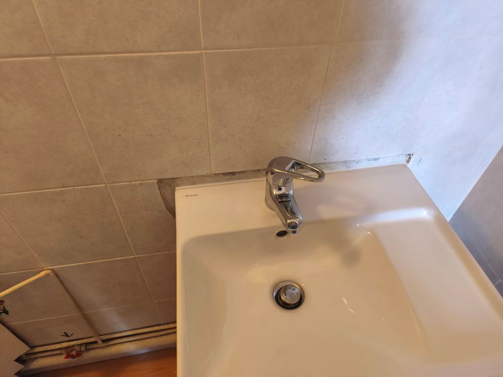 Joli lavabo tout neuf, mais quelques centimètres de carrelage manquent autour, puisque ce carrelage a été posé autour dudit ancien lavabo 