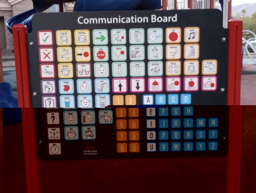 A large icon style communication board in English built into the playground structure of a city park