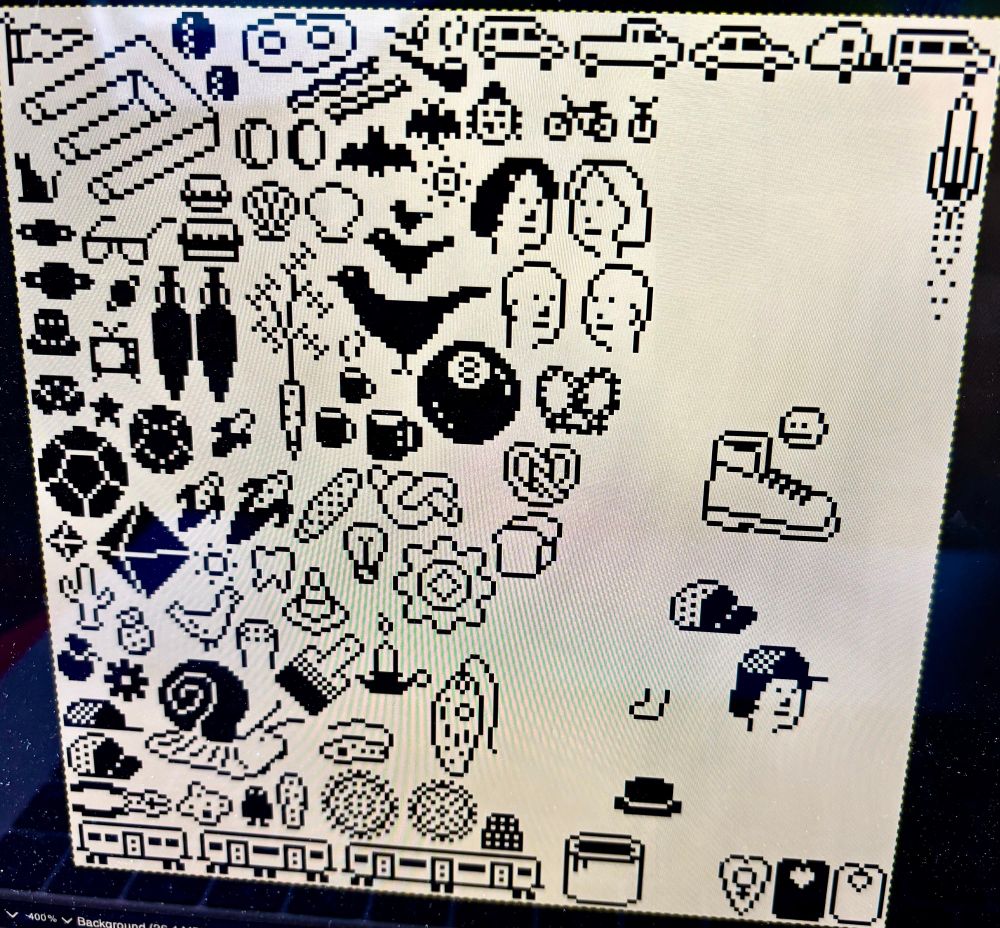 a photo of a computer screen showing a square canvas with black pixel icon drawings. vegetables, birds, vehicles, food, tools, and animals are represented. in the top left is a devil’s fork.