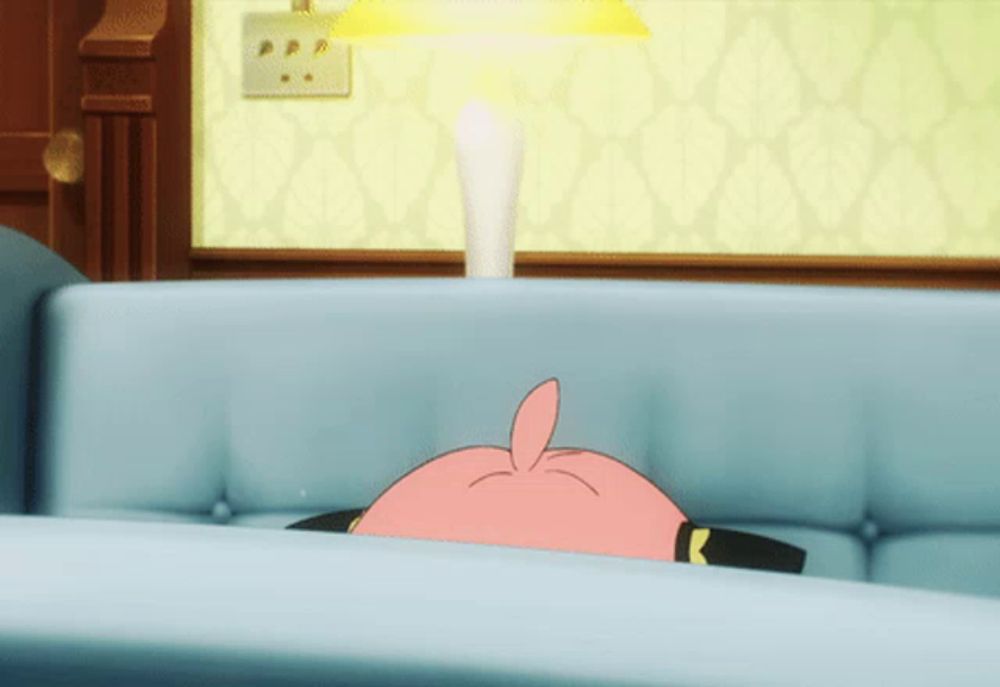 a pink cartoon character laying on a blue couch with a lamp in the background