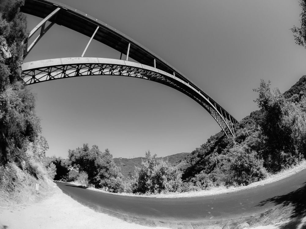 A black and white fisheye view of the Cold Springs Bridge with Stagecoach Road, with the road and bridge curving to form a circle. 

Shot on my Galaxy Note 9.