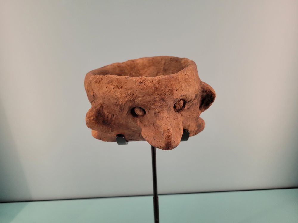 Ancient ceramic cup with ears and a nose. 