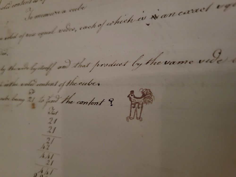 A fragment of a faded hand written letter with a small doodle of a rooster wearing pants in the margin. 