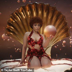 Ice Spice from Taylor Swift’s Karma music video. She’s wearing a red fit and holding a pearl while inside a giant clam. 