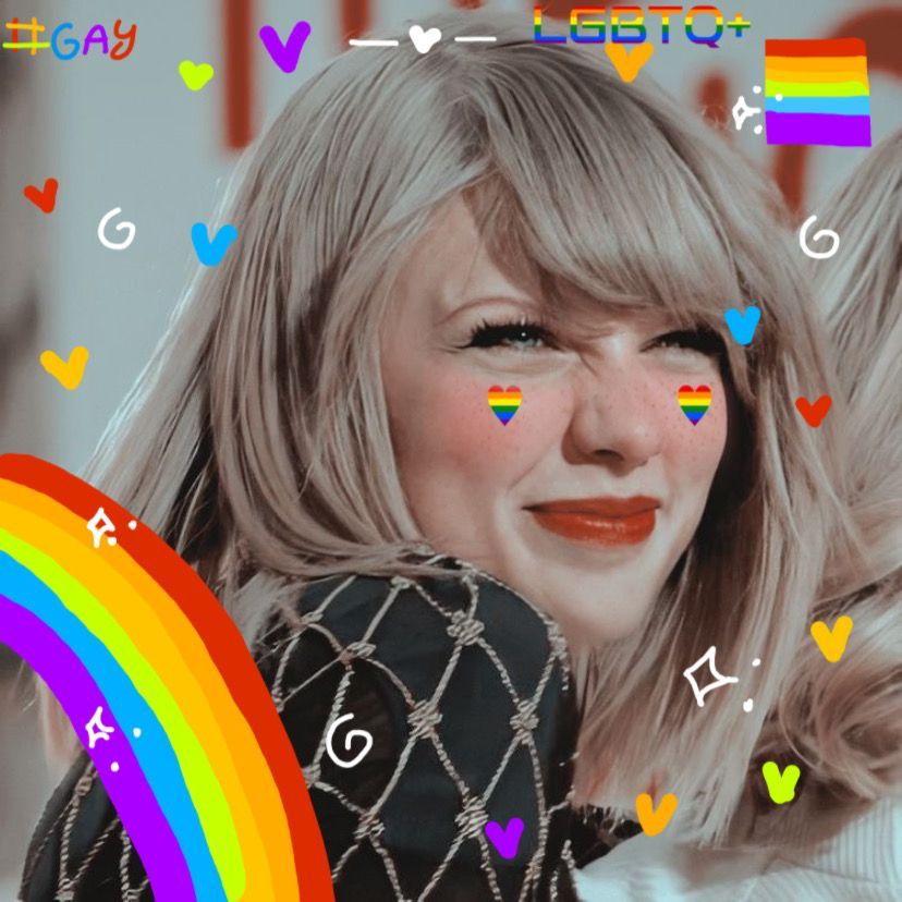 A photo of Taylor Swift smiling and scrunching her nose. There are multi-colored hearts, a rainbow, “LGBTQ+”, “#gay”, and a pride flag drawn on top of the photo