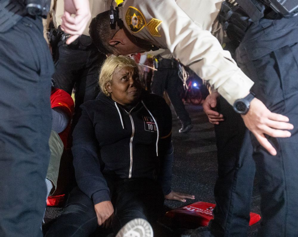 A protester is surrounded by Metropolitan Police Department officers.