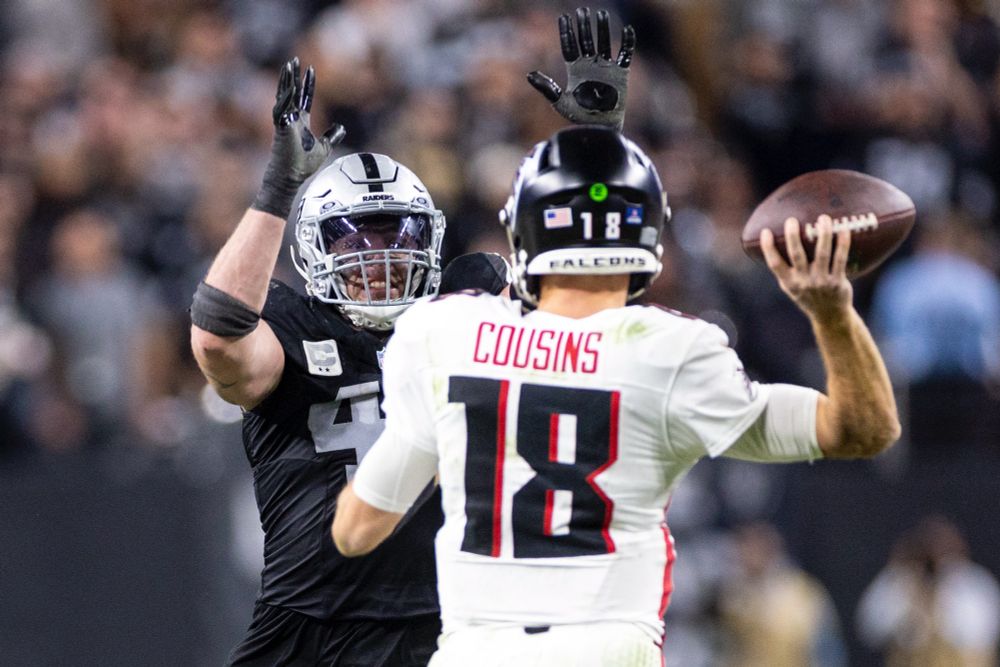 Raiders linebacker Robert Spillane, left, rushes Atlanta Falcons quarterback Kirk Cousins (18), blocking the pass and receiving a flag for roughing the passer.