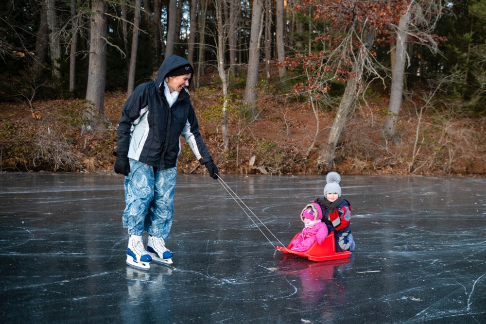 Doreen Kurtz, left, pulls daughter Corrie, center, 10 months, and son Miles, right, 2, in a plastic sled while skating.
