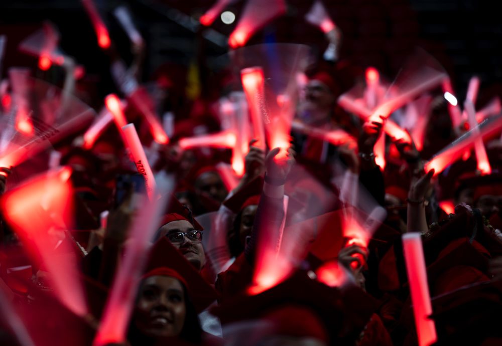 Graduates wave glow sticks after moving their tassels.