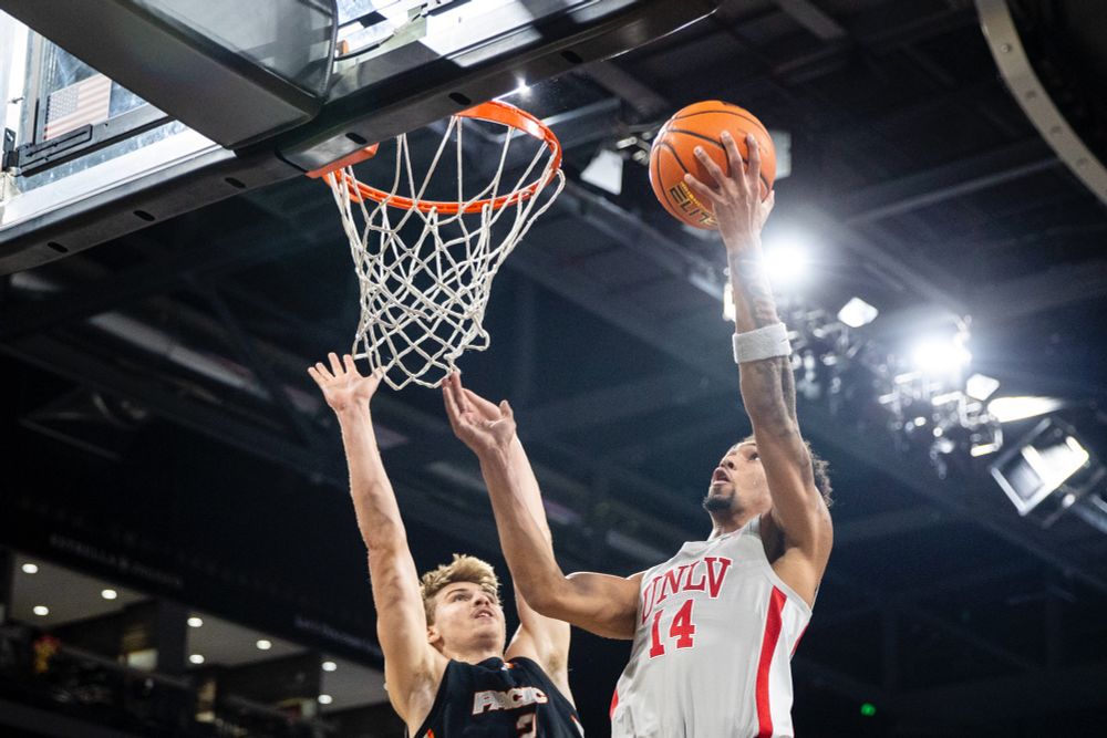 UNLV guard Jailen Bedford (14) attempts a layup past Pacific Tigers forward Elias Ralph, left.