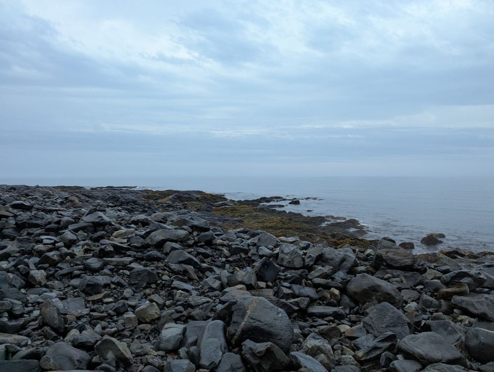 The ocean,  with a boulder beach in the foreground