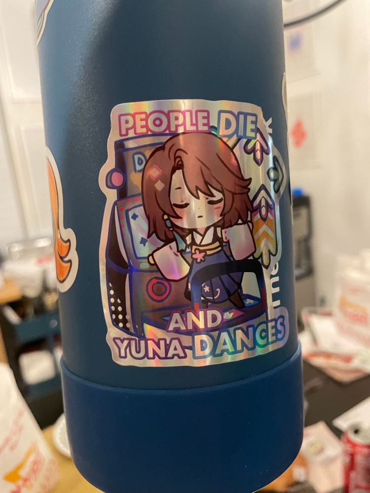 The side of a purple water bottle. This side displays a stricker of Yuna from Final Fantasy X playing DDR. It is captioned "People Die and Yuna Dances."