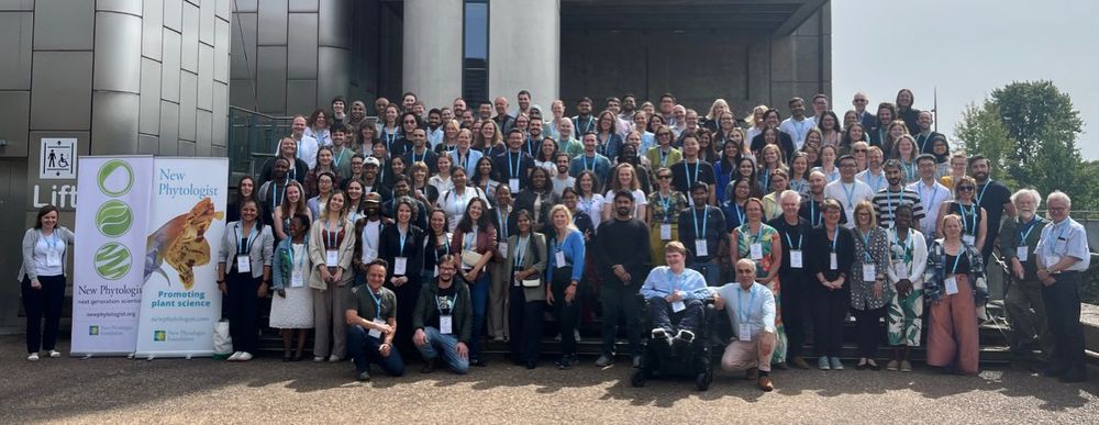 Large group of diverse scientists and researchers gathered outside a modern building for a New Phytologist next generation scientists symposium.