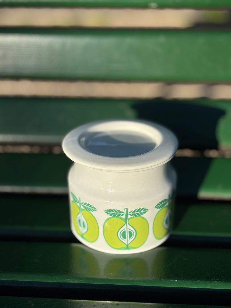 Petit pot blanc avec des pommes vertes, design nordique années 60.