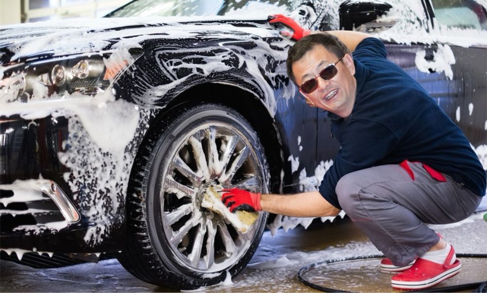 Le réalisateur Wong Kar-wai en train de laver les roues d’une voiture dans un Carwash