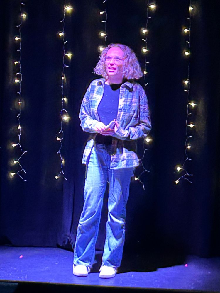 Madison on stage in jeans & flannel. 