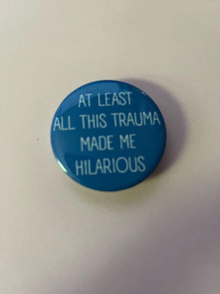 Button that says at least all this trauma made me hilarious. 