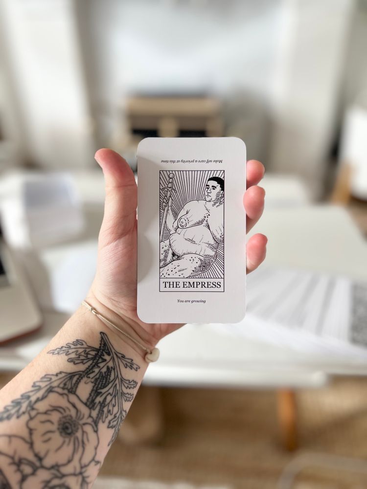 Ocean holding a tarot card he drew which is the empress 