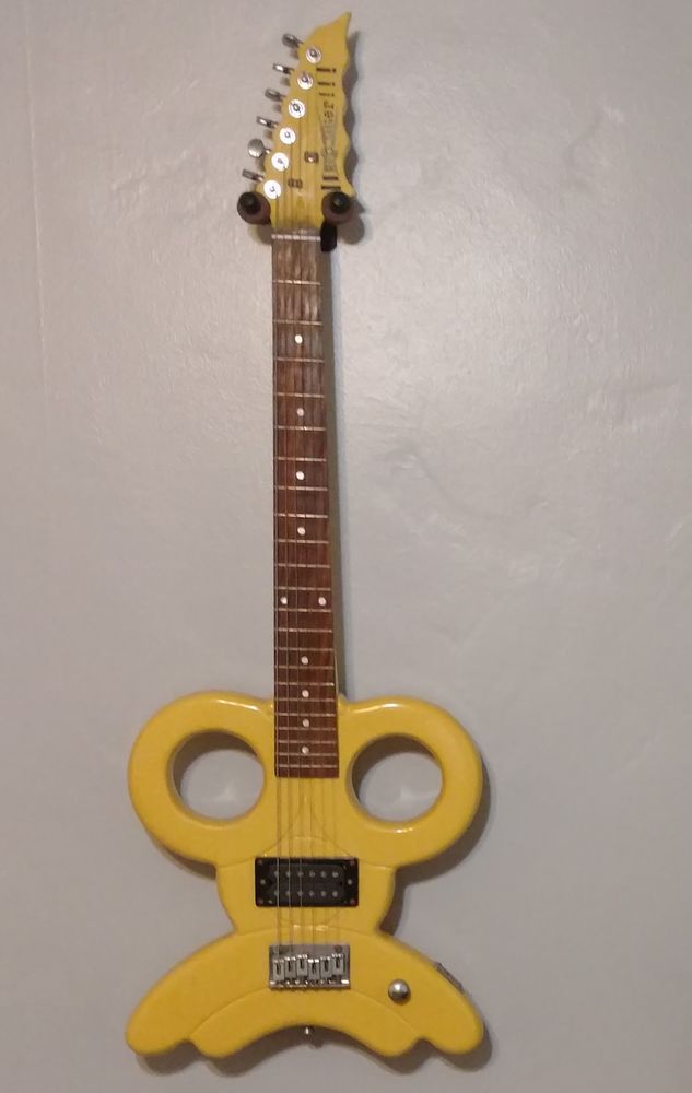 Unusual shape yellow guitar. Headstock says 