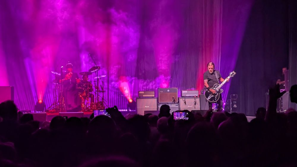 A band on stage under pink lights