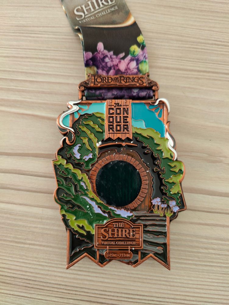 Shire medal showing a hobbit home/door.