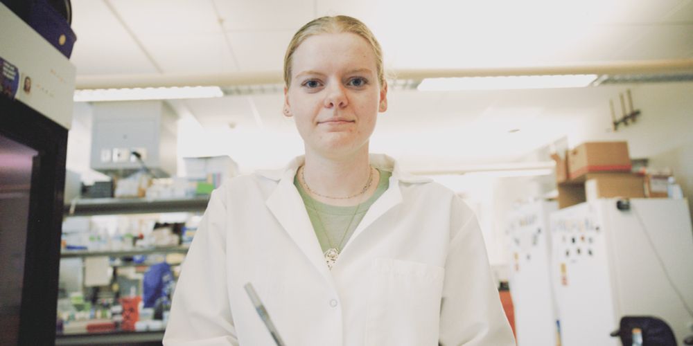 Abby standing in a white lab coat in a biology lab
