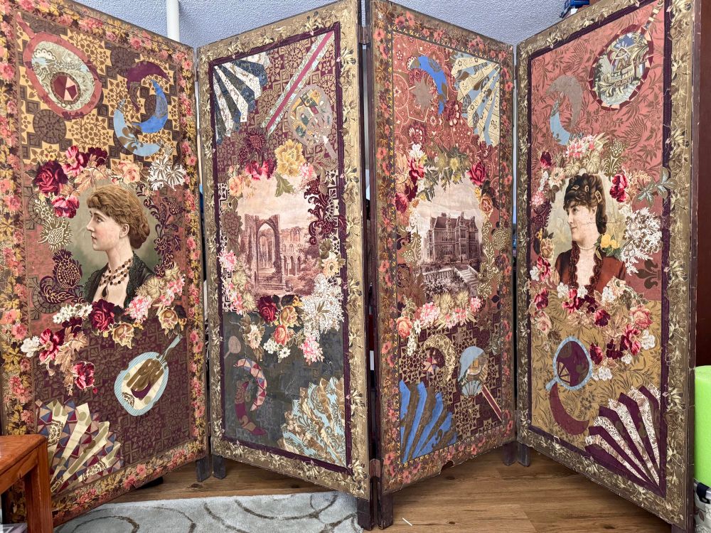 A photo of a colourful, 4-section room divider made with antique wallpaper. Each section is unique with a large cutout image of a building or woman’s profile in the centre, and surrounded by cutouts of flowers, hand mirrors & fans made from cut out pieces of what, again appear to be wallpaper. 