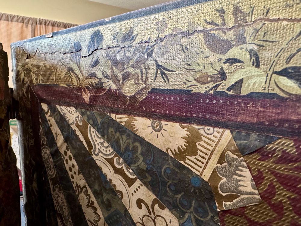 A close-up of another of the wall panels of the antique room divider made this photo again shows how different patterns of wallpaper were used to create fan patterns, how cracking had occurred around the edges of the panels, and how some spots were hand-painted to add detail and visual cohesion. 