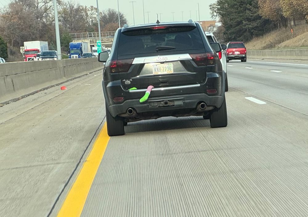 an elf leg hanging out of the rear hatch of a vehicle