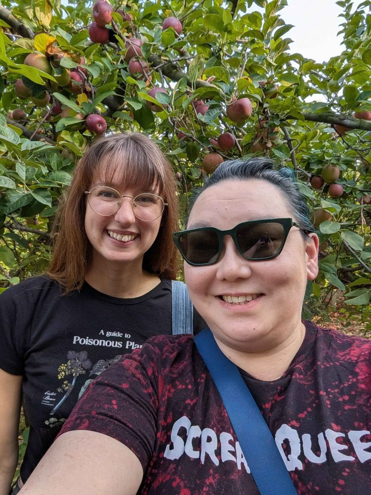 April and Rachel taking a selfie in front of an apple tree