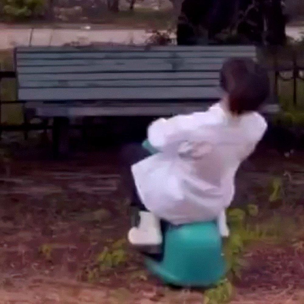 a woman in a white coat is sitting on a green chair