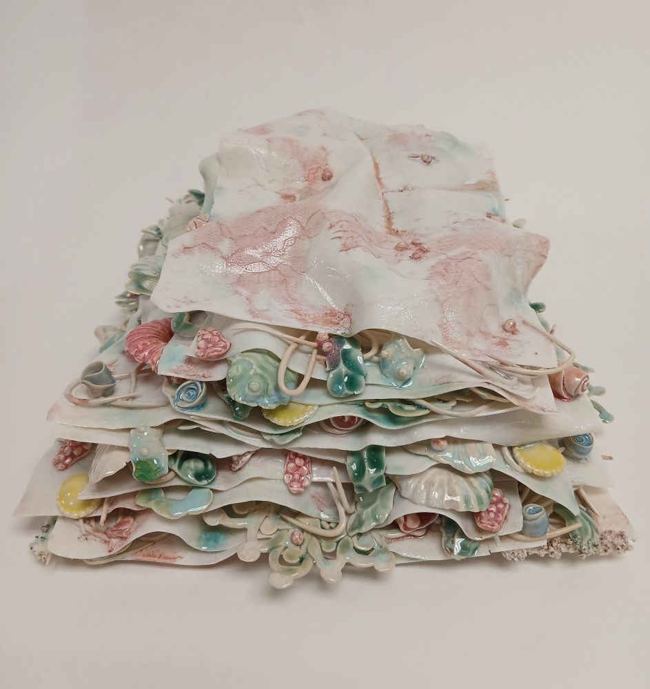Stacked porcelain sheets stuffed with elements from other past pieces in between (ceramic bones, nature and lace)