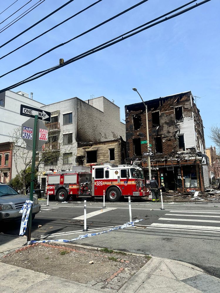 Two burned out apartment buildings with a fire truck in front of them