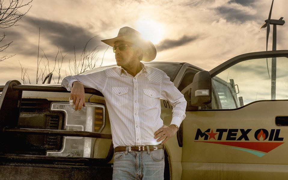 Billy Bob Thornton standing beside a work pickup truck for a show depicted in “The Patch”—a reference to West Texas oilfields in the Permian Basin. 