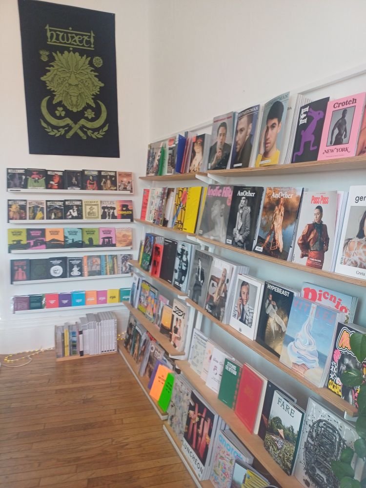 Photo of shop shelves containing small A5 zines and larger format magazines.