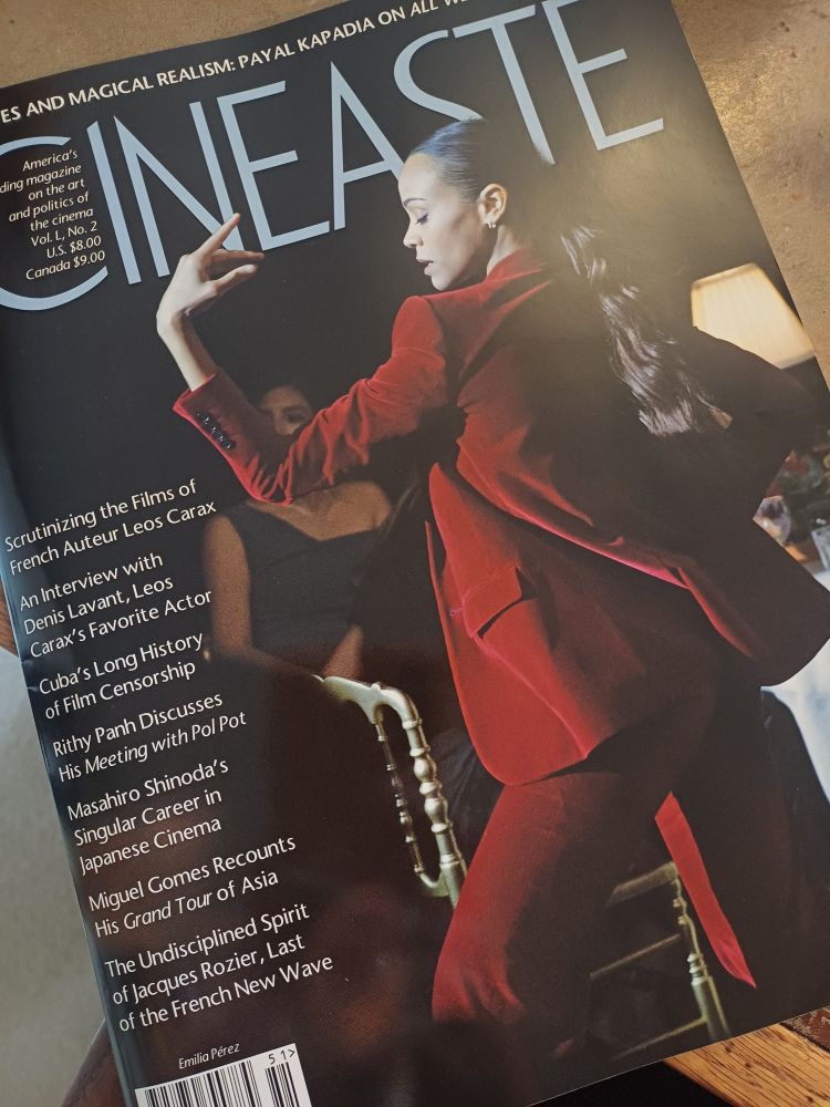 Photograph of the cover of Cineaste magazine, Spring 2025. The cover is dark, with a women in a red velvet suit dancing on one side of the cover. The other side lists, in white text, an overview of the issue's contents.