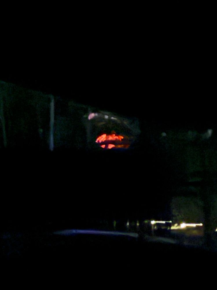 Glow of volcano as seen through trees, from miles away 