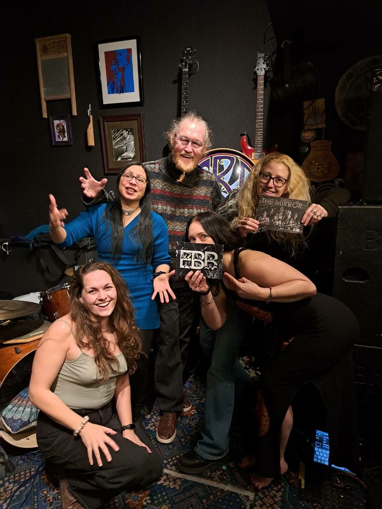 The members of EBB in their rehearsal area at The Lodge Arts Collective (also their communal home), all looking goofy and very happy holding a few copies of their finished album The Mirror, officially launching tomorrow!!!