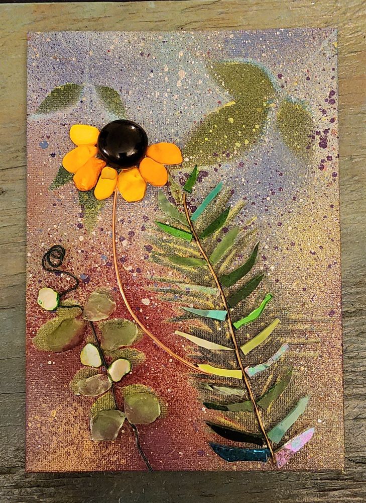 Abstract botanical with a black-eyed Susan flower and fern frond. Mixed media: acrylic paint, glass, ceramic, shell, stone, and wire on canvas board.