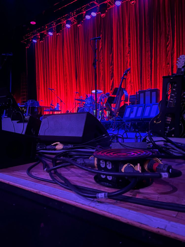 A view of a low stage from the very front set up for a music concert 
