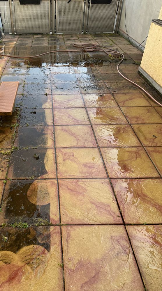 Terassenfliesen vom Ruß ganz schwarz werden mit viel Wasser gesäubert