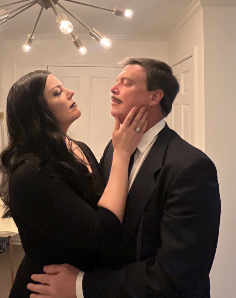 A couple cosplaying as Gomez and Morticia Addams