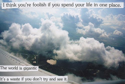 A postcard with an image of clouds and land from an airplane window. Text reads "I think you're foolish if you spend your life in one place. The world is gigantic. It's a waste if you don't try and see it."