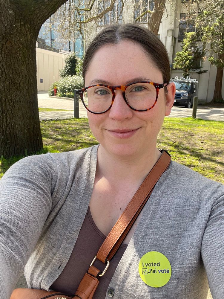 Picture of a woman wearing a sticker that says “I voted / J’ai voté”